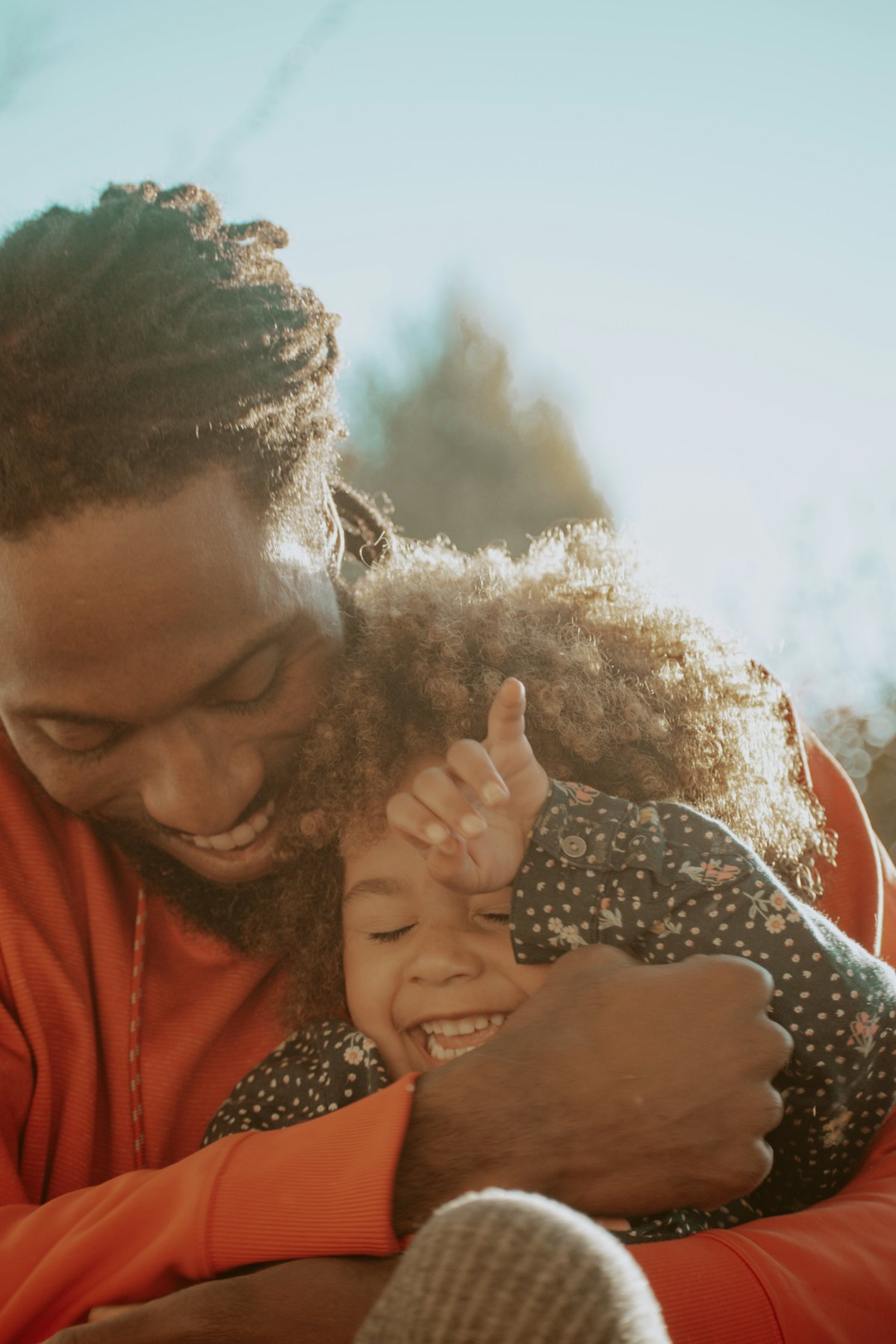 A father hugging his laughing daughter