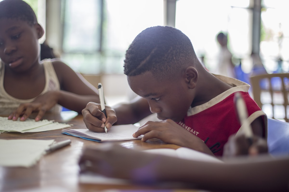 A focused young student writing